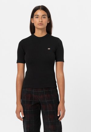 T-shirt noir ajusté à manches courtes avec un col rond et une petite étiquette de marque sur le côté gauche. Texture lisse, tissu extensible.