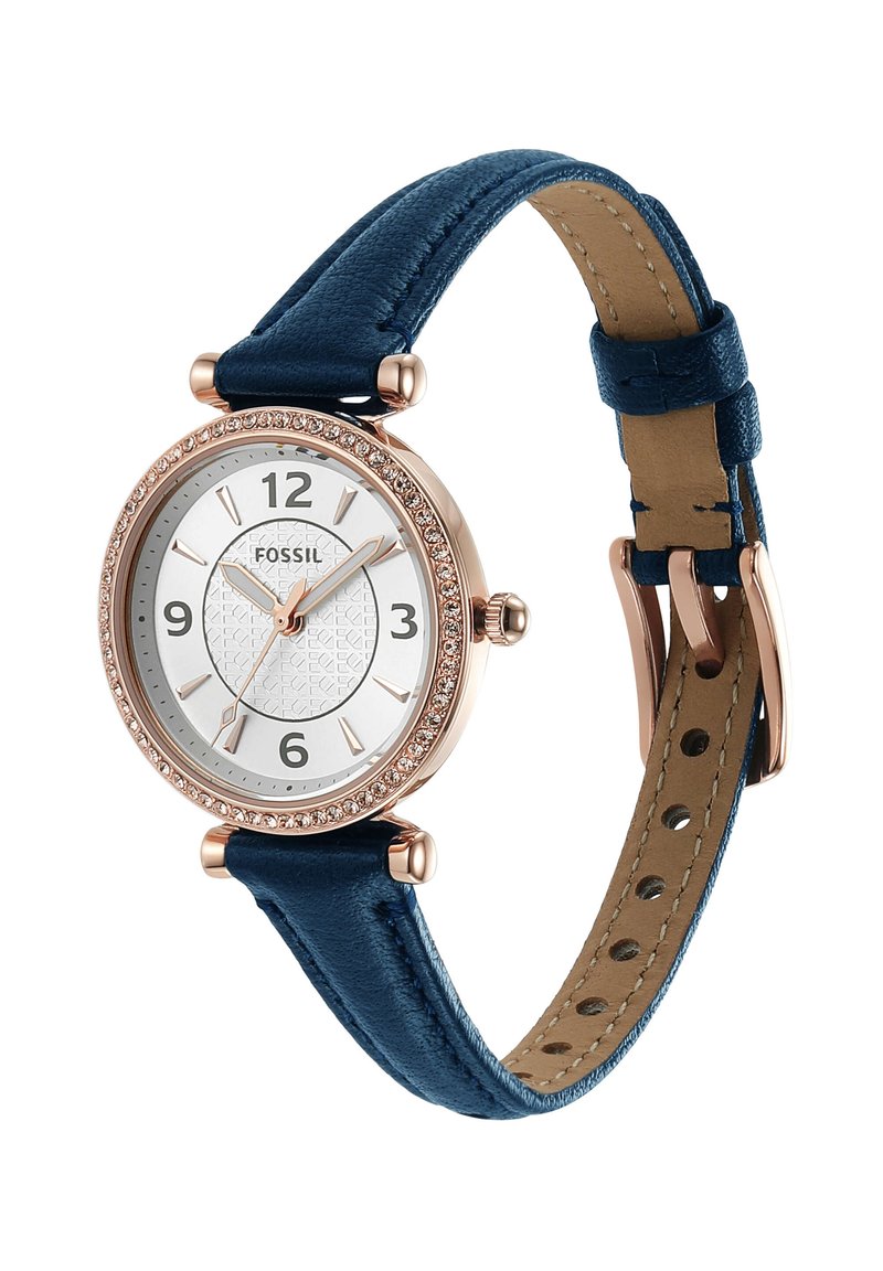 Reloj con esfera blanca redonda, bisel en tono dorado decorado con cristales, agujas doradas y correa de piel azul oscuro con cierre de hebilla.