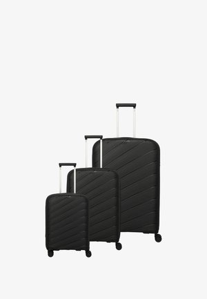 Three black hard-shell suitcases of varying sizes with diagonal grooves, silver retractable handles, and four wheels each.