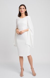 Biała sukienka o dopasowanej sylwetce, okrągłym dekolcie i charakterystycznymi długimi rękawami w formie peleryny. Gładka faktura; zestawiona z beżowymi sandałami na wysokim obcasie.