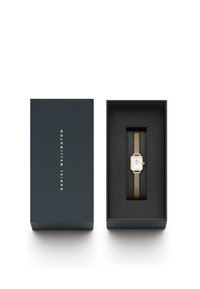 Goldmesh-Armbanduhr mit quadratischem weißen Zifferblatt in einer blauen Box, ausgestattet mit schwarzer Polsterung und markenspezifischen Innendetails.