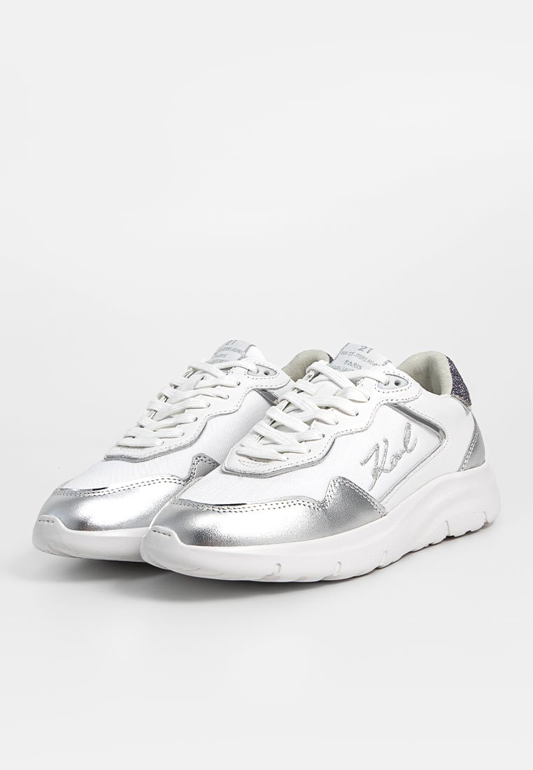 Baskets blanches de sport avec des accents métalliques argentés. Fabriquées en matériaux synthétiques, présentant un design à lacets et une semelle texturée.