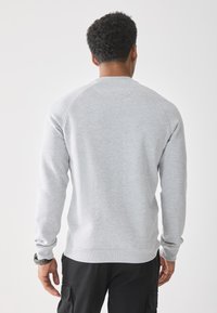Grijze katoenen sweatshirt met lange mouwen, ronde halslijn en geribbelde manchetten; casual pasvorm met een soepele textuur en minimale ontwerpelementen.