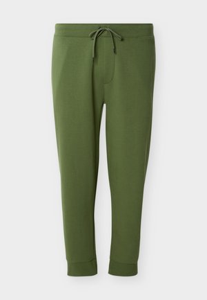 Olivgröna joggerbyxor med dragsko i midjan och mudd vid anklarna, visade mot en vit bakgrund.