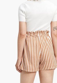 Pantalones cortos a rayas marrón y blanco con cintura elástica. Tela suave con un ajuste casual, con un diseño de talle alto.