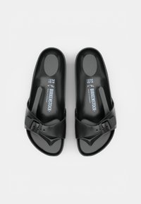 Paire de sandales Birkenstock noires à enfiler avec des brides à boucle réglables, taille 37, vues de dessus sur un fond uni.