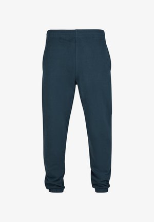 Námornícke teplákové nohavice vyrobené z jemného materiálu s elastickým pásom a priliehavými manžetami na členkoch, ktoré majú hladkú textúru a žiadne viditeľné vzory.