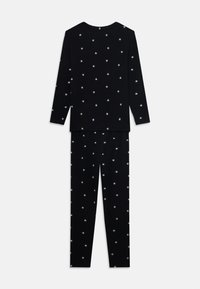 Black pajama set featuring a long-sleeve top and pants, adorned with white star patterns. Soft fabric with a relaxed fit.