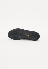 Black rubber shoe sole with textured pattern and grooves for grip; features an orange "PARETT" logo in the center.