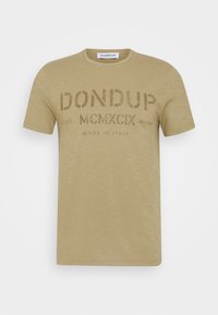 Beige bomullströja med stort tryckt varumärke på framsidan. Rund hals och korta ärmar, mjuk textur, avslappnad design.