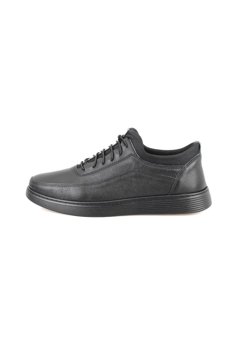 Zwarte leren sneaker met een gladde bovenkant, lage profiel, ronde neus en bijpassende veters. Geprofileerde rubberen zool met horizontale groeven.