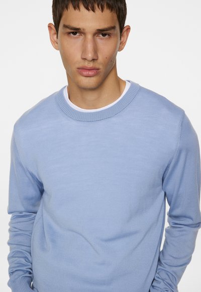 Light blue crewneck sweater with long sleeves. Smooth texture and ribbed collar, featuring a fitted style with minimal detailing.