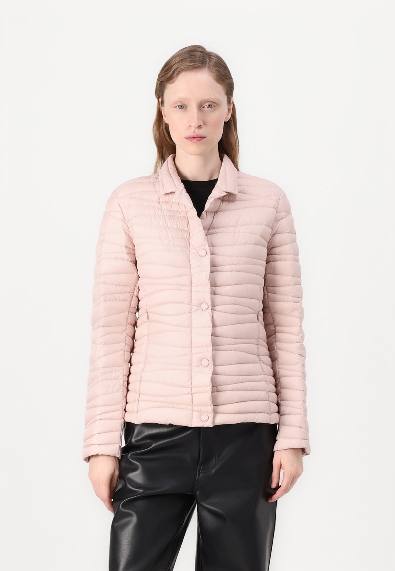 Ροζ καπιτονέ μπουφάν με γιακά τύπου notch, μπροστινά κουμπιά και οριζόντια ραφή, συνδυασμένο με μαύρο δερμάτινο παντελόνι.