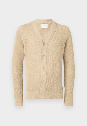 Cardigan en tricot beige avec un col en V, des boutons sur le devant et des manches longues. Présente un motif texturé sur l'ensemble du tissu.