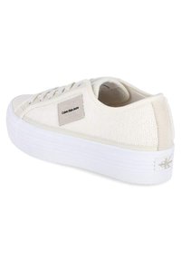 Scarpina color crema con tomaia in tessuto testurizzato, suola in gomma bianca con scanalature e patch con logo sul lato. Design low-top con lacci.