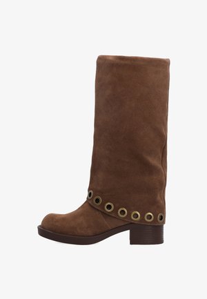 Hnědé semišové vysoké boty po kolena s kulatou špičkou, zdobené mosaznými průvlaky kolem kotníku a nízkým klínovým podpatkem.