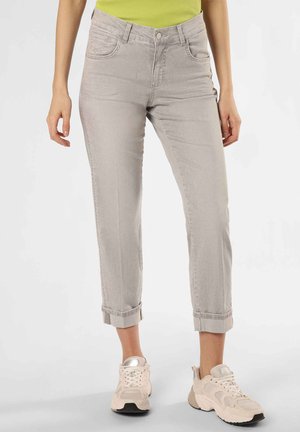 Light gray denim jeans with a relaxed fit, cuffed hems, front pockets, and a button-fly closure. Styled with a bright green top and sneakers.