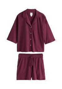 Camicetta corta a maniche corte color maroon con bottoni, abbinata a pantaloni corti con elastico in vita e cordoncino, entrambi caratterizzati da sottili strisce verticali testurizzate.