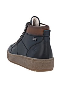 Baskets montantes en cuir noir avec une touche de marron, présentant une fermeture éclair sur le côté, une semelle en caoutchouc texturée et des coutures visibles.