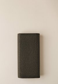 Portafoglio rettangolare pieghevole con un motivo testurizzato marrone scuro e nero a pois su uno sfondo beige chiaro.