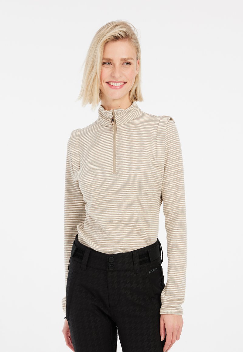 Béžový zipový top s dlouhým rukávem a texturovaným vzorem, spárovaný s černými kalhotami s houndstooth vzorem s hladkým povrchem a dvoubotkovým zapínáním.