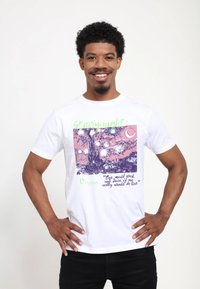 Bílé tričko s barevným grafikou stromu a noční oblohy, s textem "Hvězdná noc" a citátem od Vincenta v zelené a fialové.