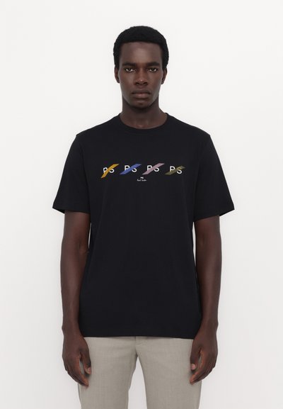 T-shirt en coton noir avec un design de texte "PS" multicolore sur la poitrine, des manches courtes et un col rond classique.