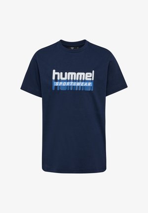 Dwoje dzieci ubrane w pasujące granatowe koszulki i spodnie sportowe marki Hummel stoją obok siebie na jednolitym tle.