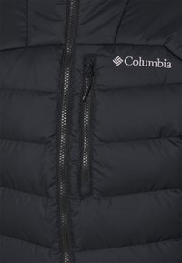 Chaqueta negra acolchada con bolsillo vertical con cremallera y logo de "Columbia" bordado en el área derecha del pecho.