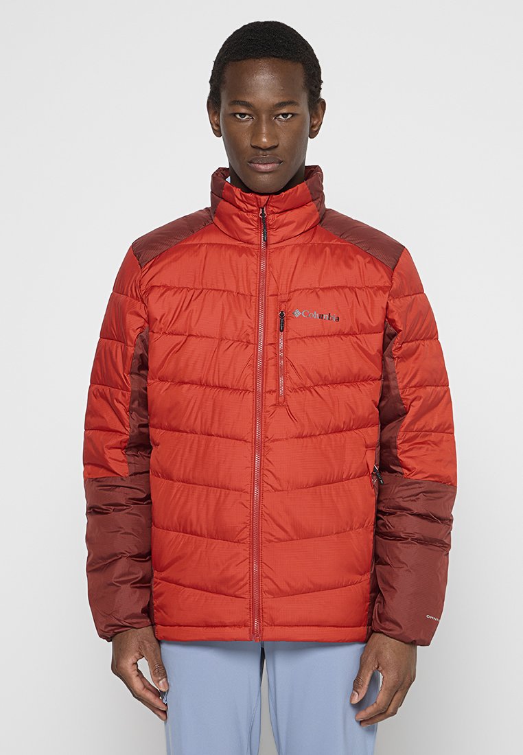 Czerwona i brązowa puchowa kurtka z wysokim kołnierzem, zamkiem z przodu i poziomymi przeszyciami. Posiada logo na klatce piersiowej oraz kieszeń boczną.