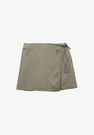 Jupe portefeuille kaki en tissu lisse, avec une fermeture à nouer sur le côté et des coutures brutes, coupée à la longueur mi-cuisse.