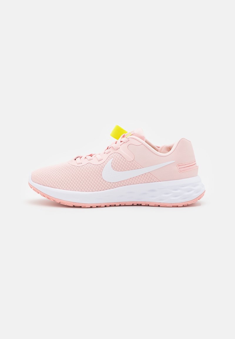 Scarpe da ginnastica rosa con tomaia in mesh, logo Nike bianco, linguetta al tallone gialla e suola bianca testurizzata. Presentano lacci piatti e colletto imbottito.