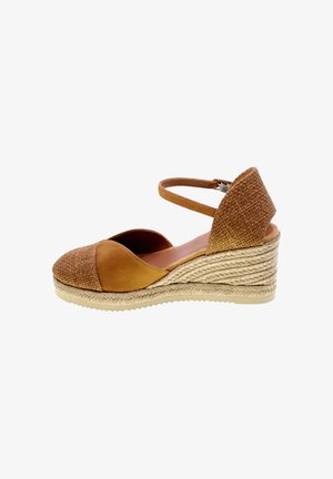 Sandalo espadrille con zeppa marrone, punta chiusa, cinturino alla caviglia e suola in juta intrecciata, progettato per un uso estivo casual.