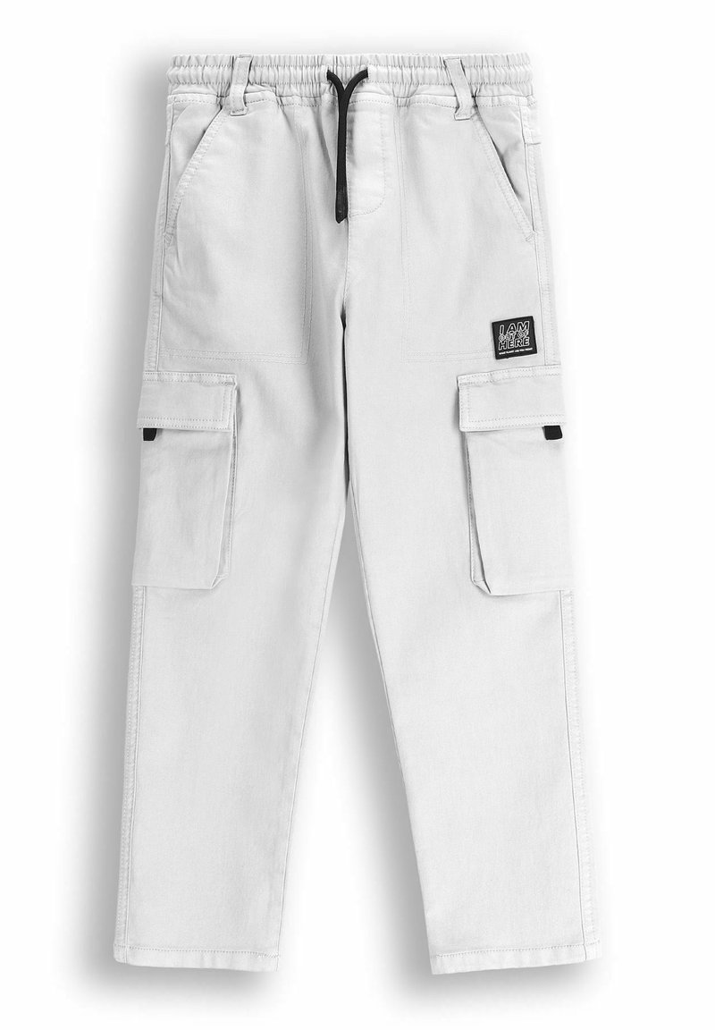 Jasnoszare spodnie cargo z elastycznym paskiem w talii, regulowanym sznurkiem, dwiema kieszeniami bocznymi i dwiema kieszeniami cargo. Naszywka "JESTEM TUTAJ" po boku.