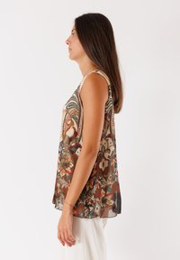 Blusa senza maniche a fantasia floreale marrone con un design fluido, realizzata in tessuto leggero, caratterizzata da dettagli intricati e una vestibilità rilassata.