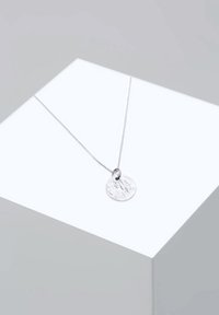Srebrny naszyjnik z teksturowanym, okrągłym wisiorkiem zawieszonym na cienkim łańcuszku; posiada małą pętlę do przyczepienia.