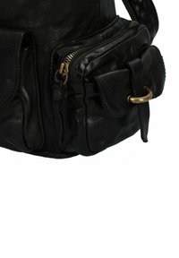 Bolso de cuero negro con un bolsillo frontal con cremallera, un bolsillo lateral con cierre de solapa y detalles en dorado. Textura suave con una forma estructurada.