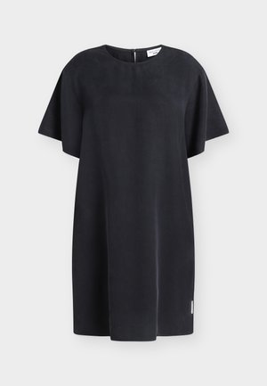 Robe courte noire à manches courtes avec encolure ronde, coupe droite et petite étiquette de marque près de l'ourlet sur un fond clair.