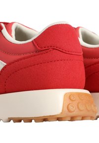 Scarpe atletiche rosse con un mix di materiali lisci e texture, con una suola intermedia bianca e una suola in gomma strutturata.