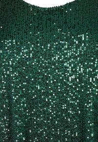 Grön paljettopp med ett texturerat tyg täckt av glänsande paljetter. Designen har rund halsringning och en tät, glittrande yta.