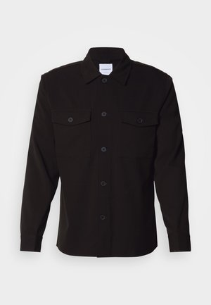Camisa negra de manga larga con un frente abotonado, dos bolsillos en el pecho y un cuello estructurado. Fabricada con una tela sólida de textura suave.