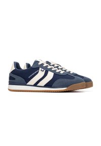 Zapatillas deportivas en azul marino y azul claro con rayas blancas, material de ante y malla, punta redonda, suela de goma beige y seis ojales.