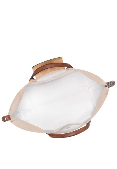Tan fabric bag with a smooth exterior, dark brown textured leather trim, and a white interior. Zippered closure with a circular pull.