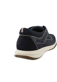 Zapatilla de ante y malla azul marino con empalmes en blanco, suela de goma y acento a rayas en el talón. Forma redondeada y cuello acolchado.