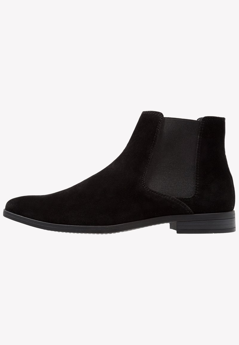 Bottine Chelsea en daim noir avec panneau latéral élastique, petit talon empilé et bout arrondi vue du côté extérieur.