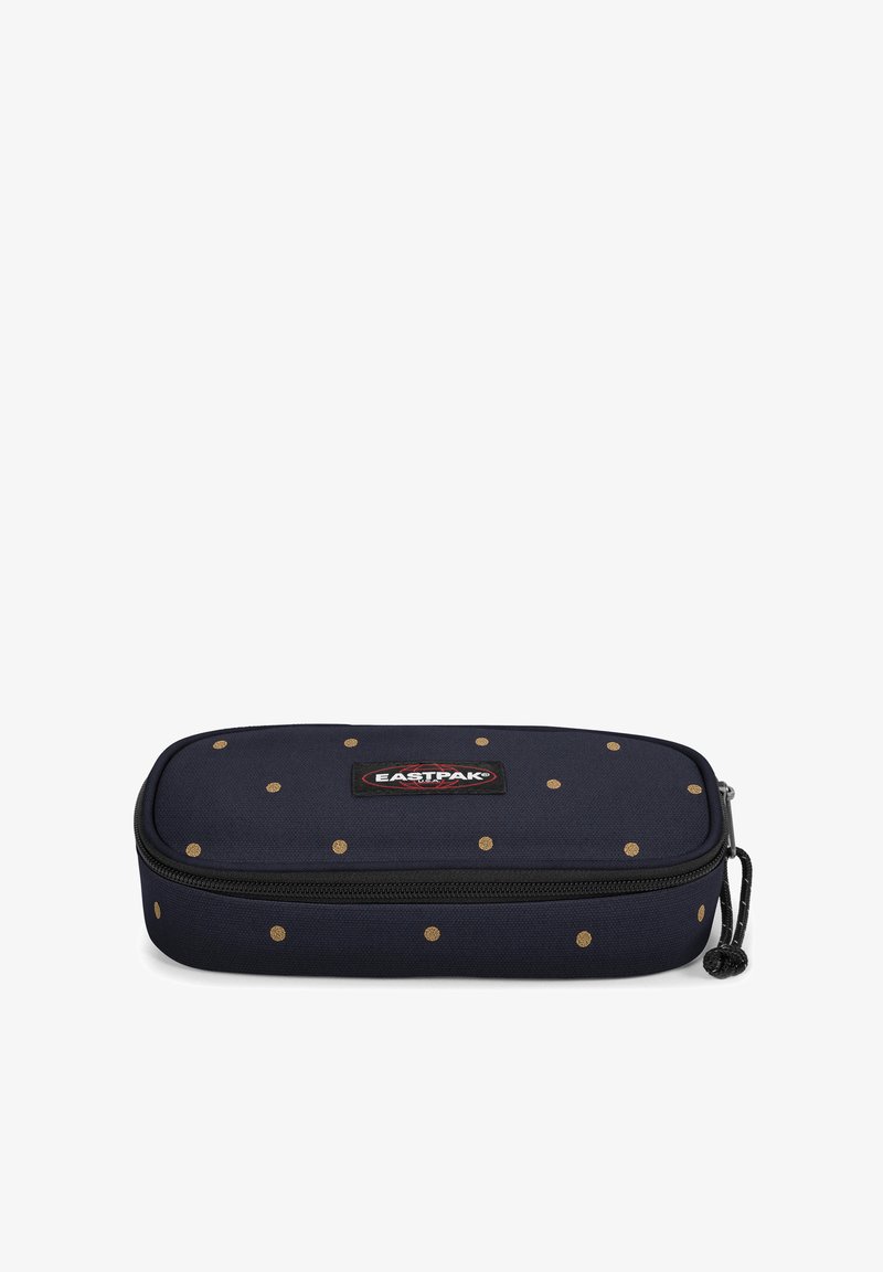 Trousse bleu marine en tissu, ornée de pois dorés, avec une fermeture éclair et un écusson logo à l'avant. Forme rectangulaire.