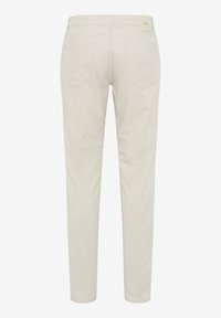 Pantalones beige de corte ajustado con bolsillos traseros y trabillas para cinturón, mostrados planos desde atrás, con una pequeña etiqueta de marca en la cintura.