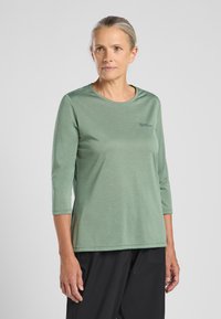 Grünes Langarmshirt mit Rundhalsausschnitt und bequemer Passform. Hergestellt aus leichtem Material. Verfügt über ein kleines Logo auf der Vorderseite.