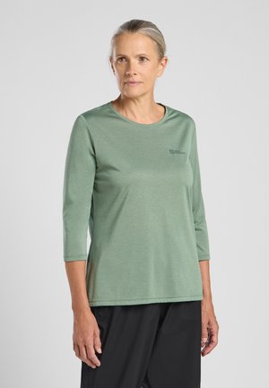 Grünes Langarmshirt mit Rundhalsausschnitt und bequemer Passform. Hergestellt aus leichtem Material. Verfügt über ein kleines Logo auf der Vorderseite.