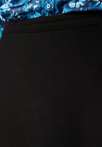 Gonna nera con un tessuto texturizzato caratterizzata da un design aderente. La vita presenta dettagli di cucitura orizzontale sottili.